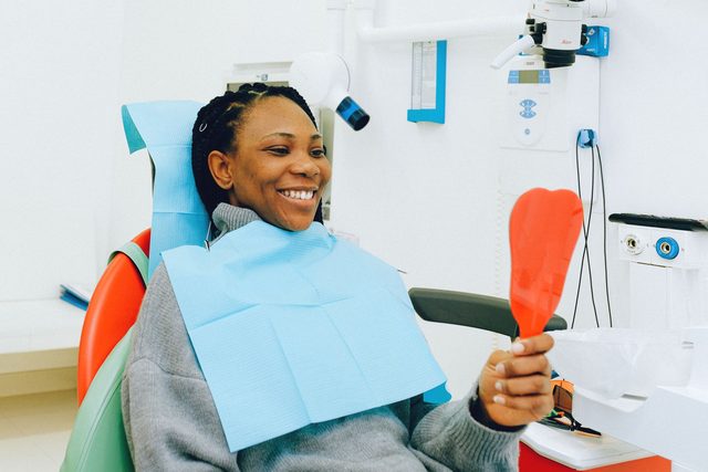 A patient smiling in the dental chair after treatment